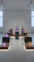 Modern gallery interior showcasing colorful crystal gemstone collection on black pedestals with professional track lighting for luxury exhibition design.