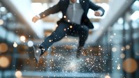 Young Asian businessman in suit jumping with magical sparkle effect and bokeh lights in modern office space, expressing success and achievement.