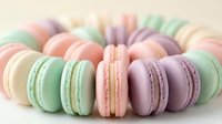 Colorful French macarons arranged in circle on light background. Pastel pink, green, purple dessert cookies for bakery menu, sweet treats display.