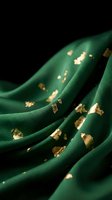 Luxurious emerald green fabric with golden foil accents creates elegant flowing waves against dark background for premium fashion and textile design.