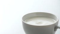Creamy white coffee or latte in ceramic cup on clean background for beverage marketing and cafe branding materials.