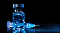 Medical vial with blue luminescent liquid and syringe on dark background, dramatic lighting creates mysterious scientific atmosphere for healthcare concepts.