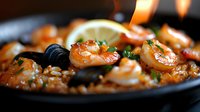 Succulent grilled shrimp with garlic, lemon and fresh herbs served on dark pan with selective focus, close up view of seafood dinner preparation.