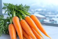 Fresh orange carrots with green tops on light background, raw organic vegetables close up view for healthy eating and cooking concepts.