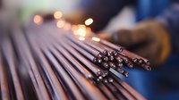 Fiber optic cables arranged in parallel lines with blurred bokeh lights in background, showcasing modern telecommunications infrastructure and network connectivity.