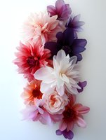 Delicate floral arrangement featuring dahlias and roses in shades of pink, purple, and white against light background, creating soft romantic composition.