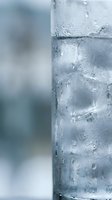 Glass of ice water with condensation droplets on exterior surface, perfect for beverage, refreshment, hydration, and wellness related designs.