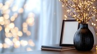 Cozy home interior with decorative vase, books and warm bokeh lights creating ambient atmosphere for relaxation and comfort.