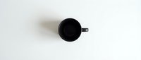 Empty black mug on white background, isolated cup ready for mockup designs, branding projects, and product presentations.