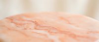 Soft peach marble surface with natural veining patterns for luxury interior design and elegant product display backgrounds.
