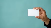 Hand of a middle-aged man with medium skin tone holding a blank white business card against a turquoise background. Suitable for corporate branding, business identity, and marketing materials.