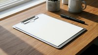 Blank clipboard with white paper on wooden desk next to coffee mug and pen, ready for writing notes or documents in bright office workspace.