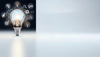 Glowing light bulb with innovation icons and gears on dark background representing creative business ideas and technological solutions for presentations.