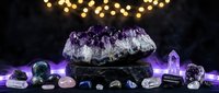 Amethyst crystal cluster on dark stone pedestal surrounded by healing gemstones, glowing purple lights, mystical spiritual energy concept.