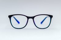 Modern black eyeglasses with blue temple tips on white background, front view of stylish optical frame for vision correction and fashion accessories.