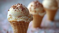 Creamy vanilla ice cream scoops in waffle cones topped with chocolate sprinkles, soft focus background creates dreamy dessert composition. Perfect for food marketing.