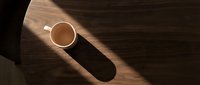 Coffee cup with saucer on wooden table in sunlight, casting long shadow. Overhead view for café, beverage, and morning routine designs.