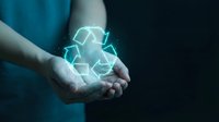 Hands holding glowing recycling symbol with neon light effect on dark background, representing environmental sustainability and eco-friendly practices.