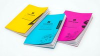 Colorful notebooks with pens arranged on white background, featuring yellow, cyan, and magenta covers. Isolated stationery for design projects.