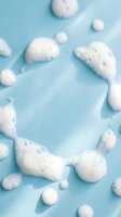 Soap bubbles and foam arranged on light turquoise background, creating circular and organic shapes. Suitable for cleaning product advertising, hygiene concepts, and spa wellness designs.