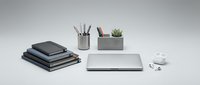 Modern minimalist office desk setup with laptop, notebooks, stationery organizers and small plant on clean white background for professional workspace design.
