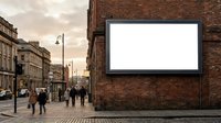 Large blank white billboard mounted on red brick building wall in urban city street with pedestrians walking by for advertising mockup.