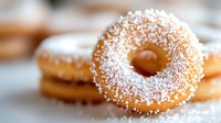 Fresh glazed donuts with powdered sugar coating on white background, sweet bakery treats for breakfast menu and cafe advertising.