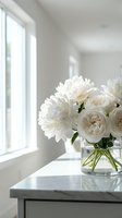 White peonies and roses in glass vase on marble table by bright window creating elegant minimalist home decor arrangement for interior design projects.