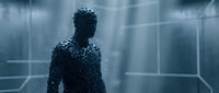 Humanoid figure composed of digital particles and data streams standing in futuristic virtual environment with glowing grid lines and blue light effects for technology and innovation concepts.