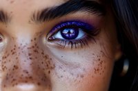 Close-up of eye with vibrant purple makeup and contact lens showing futuristic digital pattern, freckled skin visible around eye area. For beauty and sci-fi concepts.