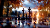 Chess pieces on board against autumn sunset background with bokeh lights and fallen leaves creating magical atmosphere for strategy games and competition.