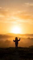 Child silhouette with raised arms celebrating golden sunrise over misty mountain landscape. Freedom, hope, and new beginnings concept for inspirational content.