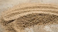 Close-up of fine sand texture with natural ripple patterns, suitable for backgrounds, nature themes, and environmental design projects.
