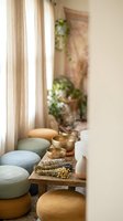 Meditation room with singing bowls, sage bundles and colorful floor cushions creating peaceful wellness space for mindfulness practice and relaxation.