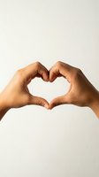 Two hands forming a heart shape gesture on a light background, symbolizing love, care, and unity for Valentine's Day or charity concepts.