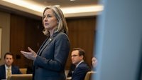 Professional middle-aged Caucasian businesswoman presenting in corporate boardroom meeting with colleagues, executive leadership conference discussion.