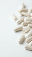 White capsules scattered on clean background for pharmaceutical and healthcare supplement marketing materials.