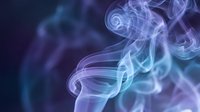 Abstract purple and blue smoke swirls creating elegant flowing patterns against dark background for creative design projects and artistic compositions.