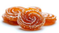 Orange spiral fruit jelly candies with sugar coating on white background, sweet confectionery treats for dessert and snack concepts.