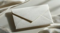 White envelope on soft fabric with gentle shadows creating minimalist composition for business communication and correspondence concepts.