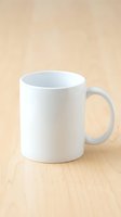 White ceramic coffee mug on wooden table surface ready for custom design and branding mockup template for promotional merchandise and marketing materials.