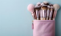 Professional makeup brushes set in pink leather case against pastel blue background for beauty industry and cosmetic advertising.
