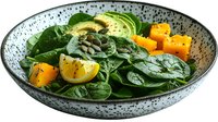 Fresh spinach salad with sliced avocado, butternut squash cubes, pumpkin seeds and lemon wedges served in spotted ceramic bowl on dark background.
