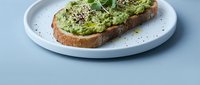 Avocado toast with seeds and herbs on rustic bread served on white plate, healthy breakfast meal for social media and restaurant menus.