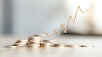 Stacked coins with rising golden graph line showing upward trend, representing financial growth, investment success and increasing profits on light background.