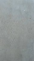 Gray concrete surface with natural texture and small aggregate stones creating industrial background for modern design projects.