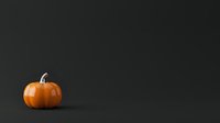 Orange pumpkin with stem isolated on dark background, suitable for autumn, fall, Halloween designs, greeting cards, seasonal marketing materials and holiday decorations.