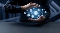 Businessman in dark jacket holding glowing digital network globe with connected icons, representing global communication, data connectivity, and technology innovation for business solutions.