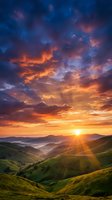 Dramatic sunset over rolling green hills with golden sun rays breaking through vibrant orange and purple clouds, creating a stunning landscape scene for nature and travel projects.
