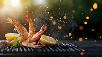 Grilled prawns with lemon slices on dark background with golden bokeh lights and spice particles flying in air, dramatic food photography composition.